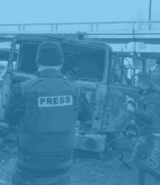 Press standing in front of destroyed truck